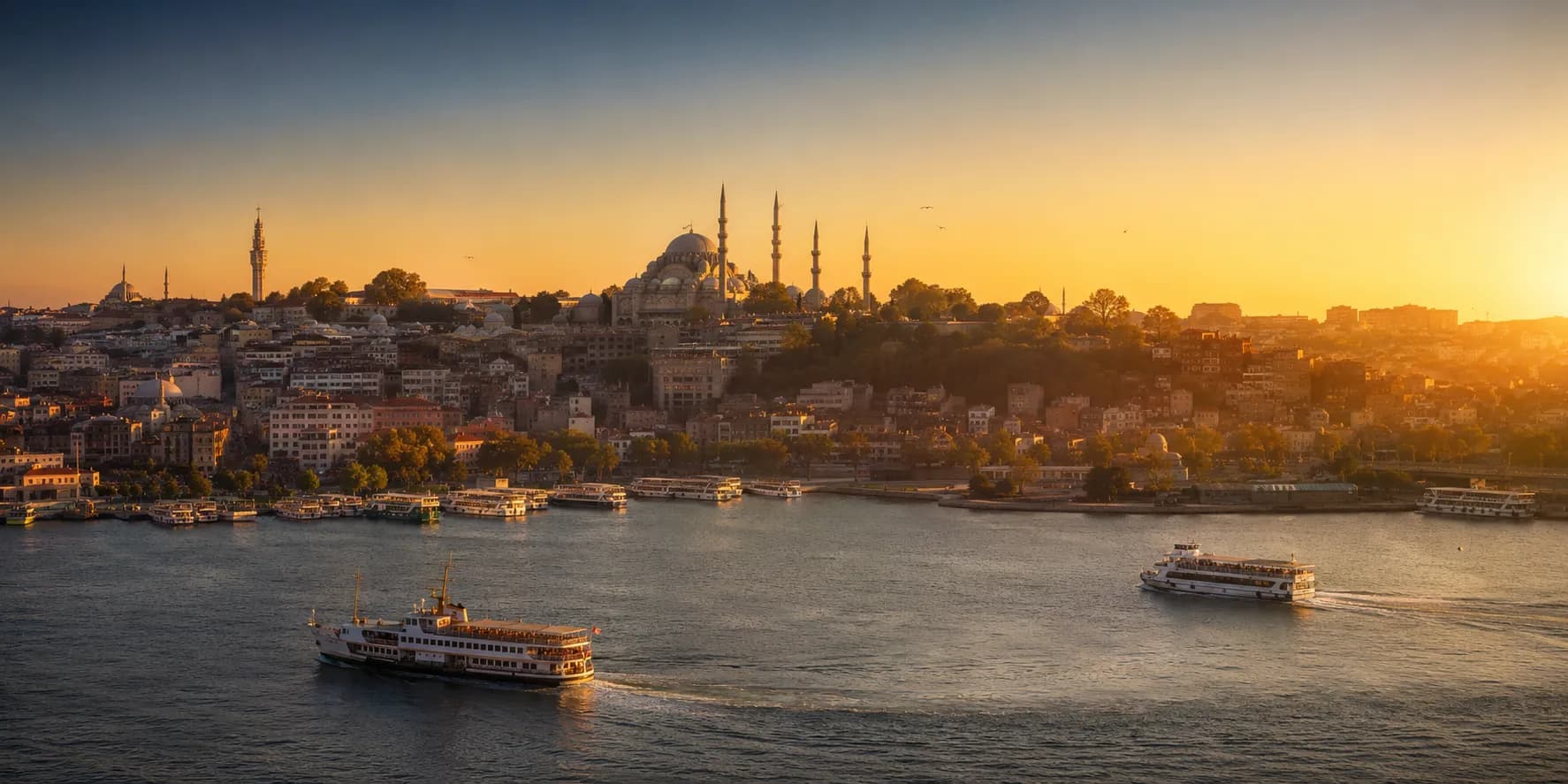 The Golden Horn at sunset, ferries crossing beneath the domes and minarets of Istanbul's old city skyline