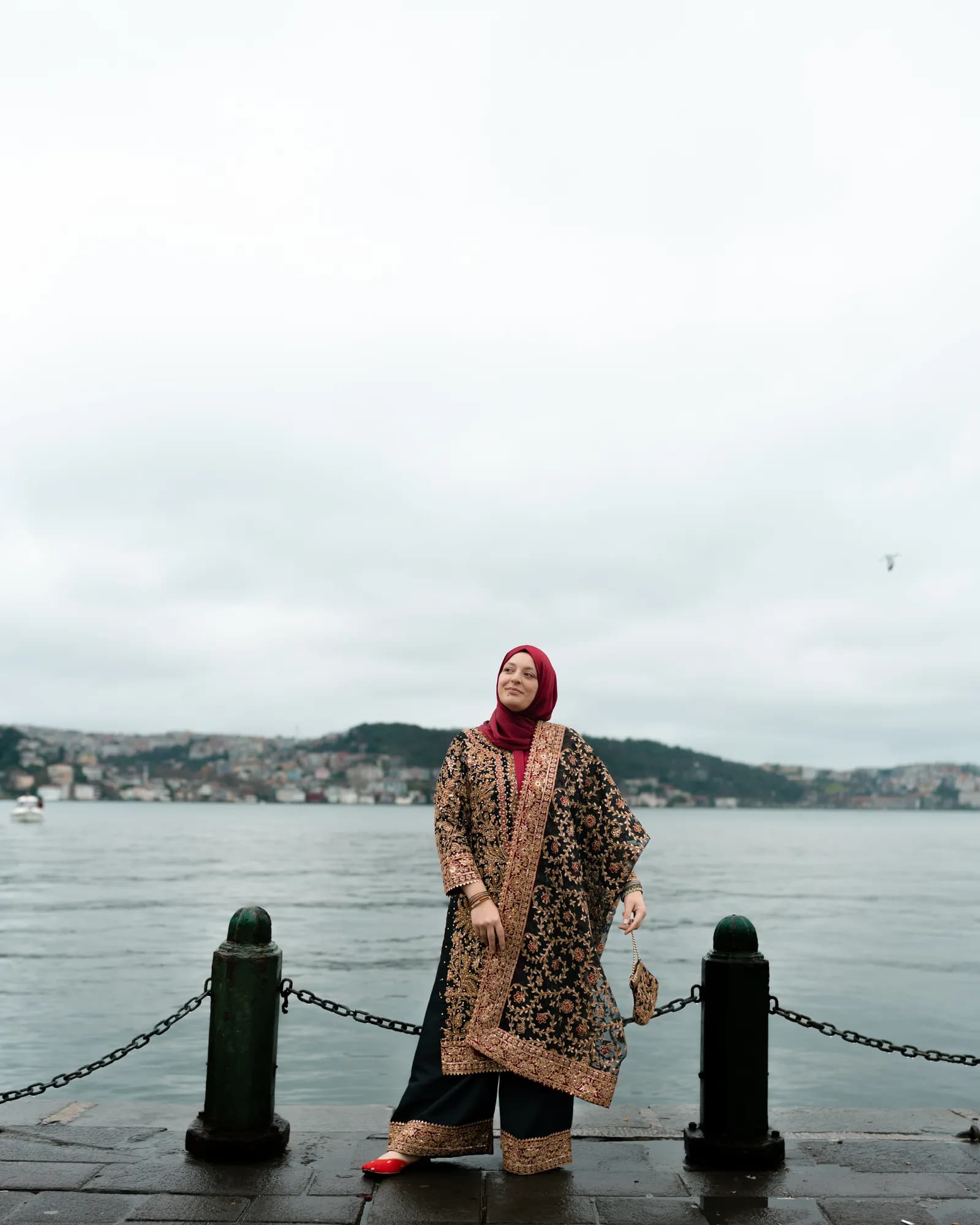 Türkan Atay on the Bosphorus waterfront in Istanbul, the hills of the Asian shore behind her