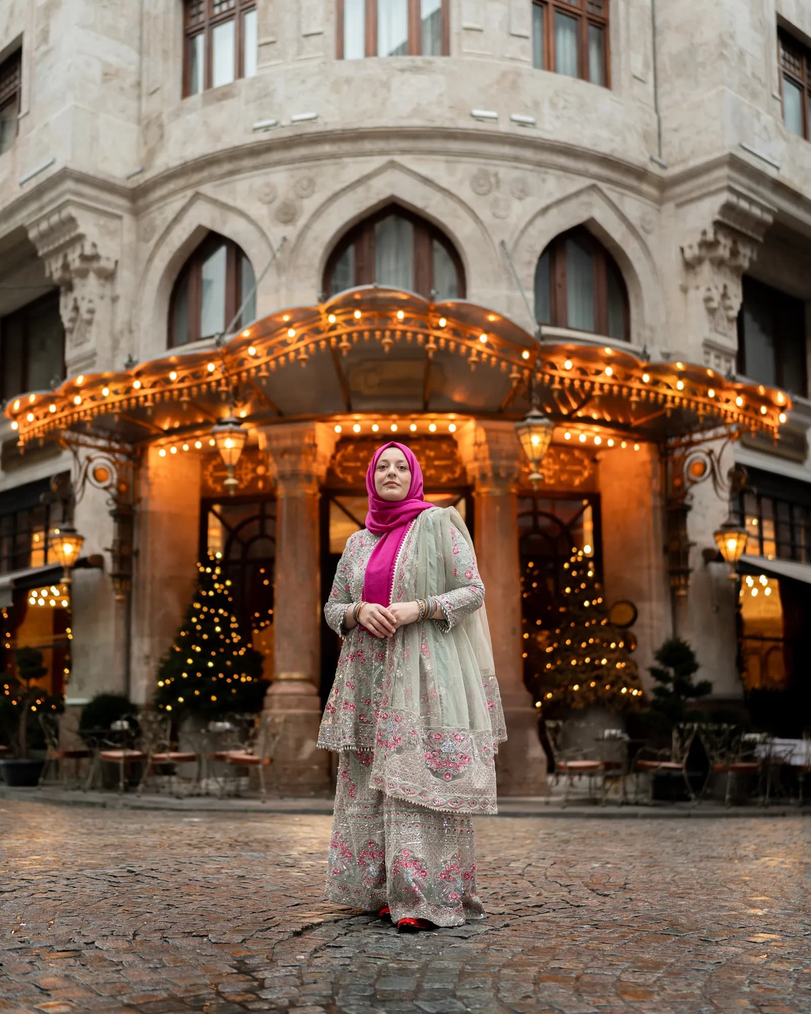 Türkan Atay, founder of Turkan Travels, outside an illuminated hotel entrance in Istanbul on a winter evening
